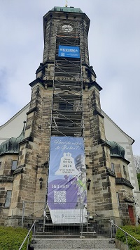 Stadtkirche mit Gerüst und Plakat für Glockenweihe